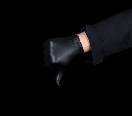 cook in black uniform shows gesture dislike with hand, black backgroundの写真素材