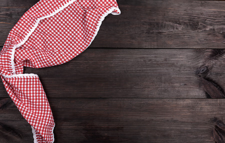 red textile towel in a white cell on a brown wooden  background, copy spaceの写真素材