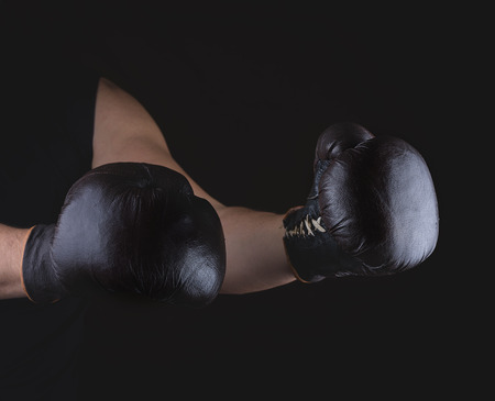 men's hands are wearing old leather brown boxing gloves, close up