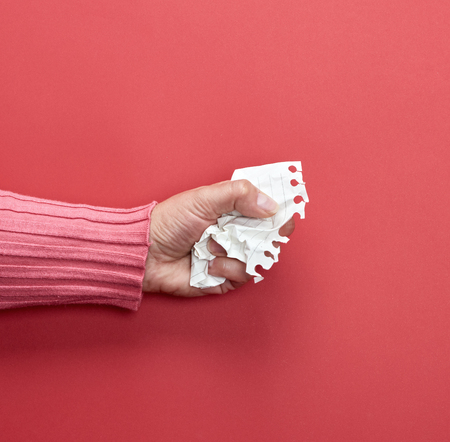 female hand holding a white crumpled sheet of paper, copy spaceの写真素材