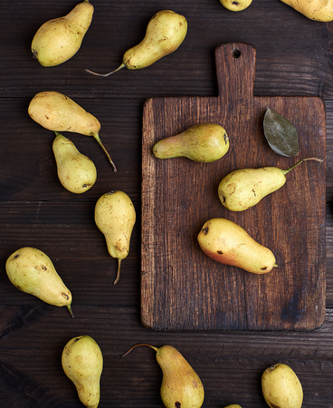 fresh ripe yellow pears on a brown wooden table, top viewの写真素材