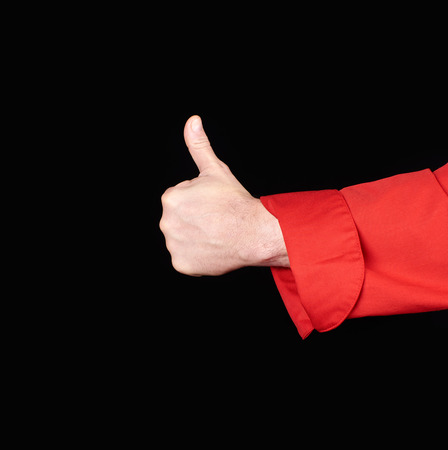 male chef's hand in  red uniform shows a gesture of approval, like, black backgroundの写真素材