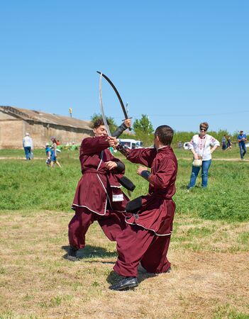 Kherson, Republicanets village, National park Kam'janska Sich , UKRAINE - APRIL 30, 2018: young men in traditional clothes Ukrainian Cossack saber fight showのeditorial素材