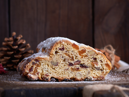 slice traditional European cake Stollen with nuts and candied fruit dusted with icing sugar