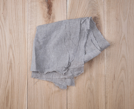 folded gray towel on brown wooden background, top viewの写真素材