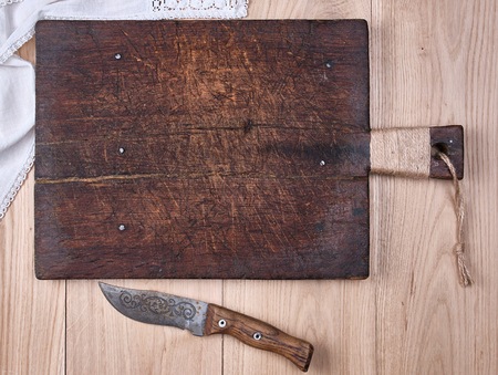 old wooden kitchen cutting board and knife on a  table, the view from the topの写真素材