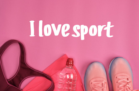 femal sports sneakers and a  water bottle on a pink background, inscription I love sportの写真素材