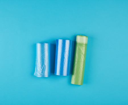 three rolled up rolls with plastic garbage bags on a blue background