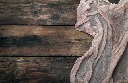 gray textile napkin, brown wooden background, top view, copy spaceの写真素材