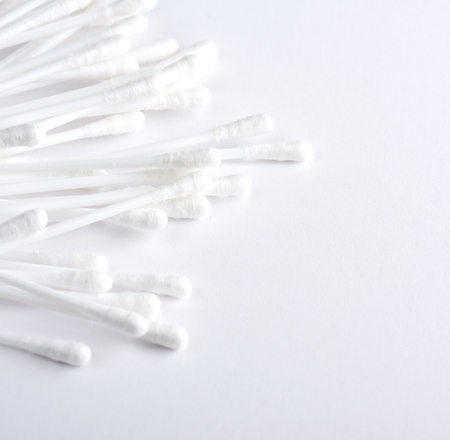 plastic sticks with white cotton for ear cleaning and other hygiene procedures on a white backgroundの写真素材