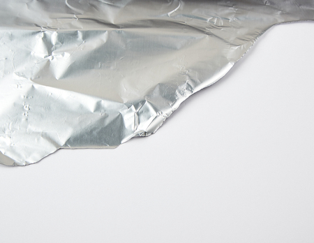 Ragged edge of silver foil on white background, close upの写真素材
