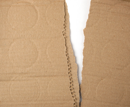 torn in half brown sheet of paper from under the box, a slot in the middle, full frameの写真素材