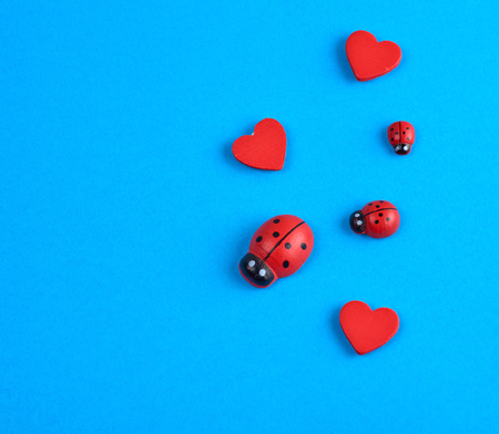 wooden decor red heart and ladybug on a blue background, close upの写真素材