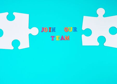 paper blank white puzzle on a blue background, inscription join our team, concept of recruitment. Teamwork business concept.の写真素材