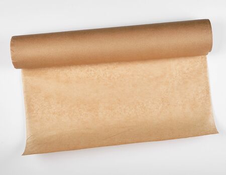 rolled brown parchment paper roll for baking on a white backgroundの写真素材