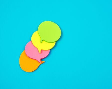 stack of multicolored empty paper stickers in the form of clouds on a blue background, copy spaceの写真素材