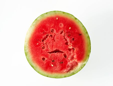 half ripe red watermelon with brown seeds on a white background, top viewの写真素材