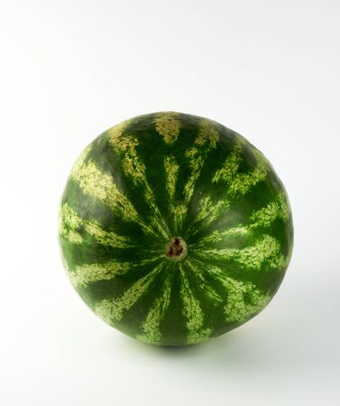 big green striped whole watermelon on a white background, summer berry, side viewの写真素材