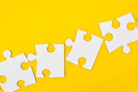 blank white big puzzles on yellow background, flat layの写真素材