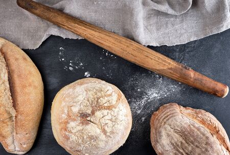 baked various loaves of bread on a black background, top viewの写真素材