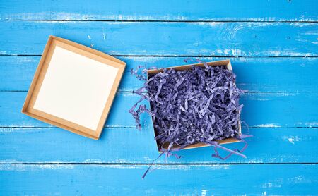 open empty brown craft box on a blue wooden background, top view, holiday backdropの写真素材