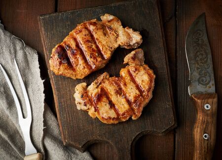 pork fried steak lies on a vintage brown wooden board, top view