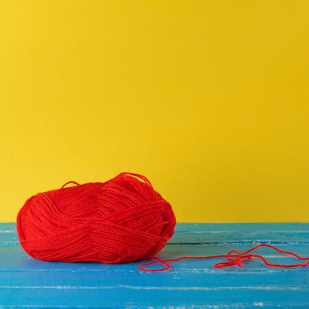 big skein of red wool on a blue background,  close up