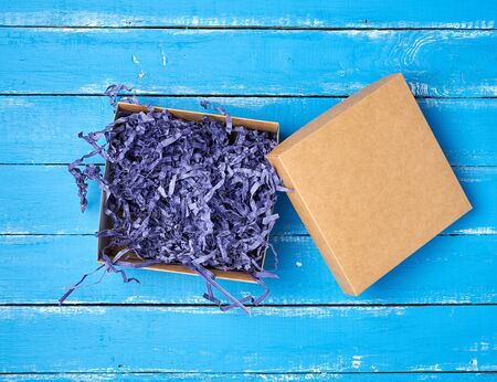 open empty brown craft box on a blue wooden background, top view, holiday backdropの写真素材