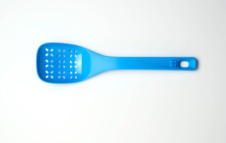 blue plastic spoon with holes for mixing salad on a white background, top viewの写真素材