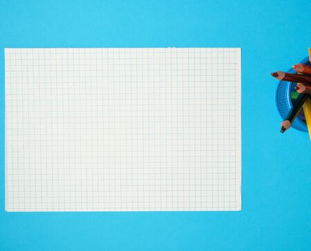 piece of paper from a school notebook in a cage on a blue background, concept back to schoolの写真素材