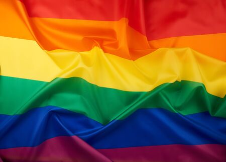 textile rainbow flag with waves, symbol of freedom of choice of lesbians, gays, bisexuals and...