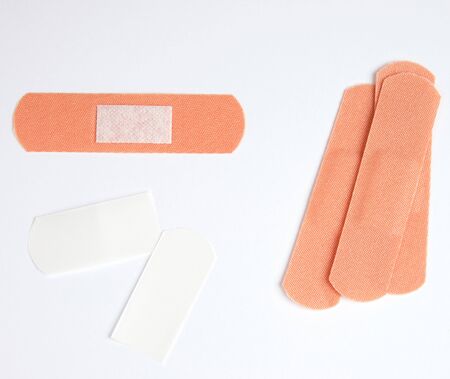 brown textile sticky patch for wounds on the skin of the body, white backgroundの写真素材
