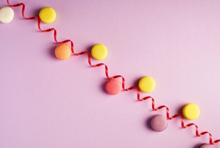 round yellow baked multi-colored macarons with cream lie and serpentine, top viewの写真素材