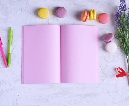 open notebook with blank pink pages, red, green pencil and a bouquet of lavenders on a white background, top view, flat layの写真素材