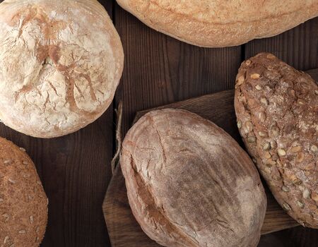 baked various breads on wooden background, top view