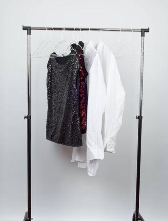 black women's blouse with red sequins, white men's shirts hang on a white iron hanger, sale conceptの写真素材