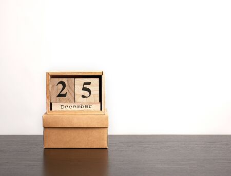 wooden calendar of cubes with the date of December 25 and brown box, festive Christmas backgroundの写真素材