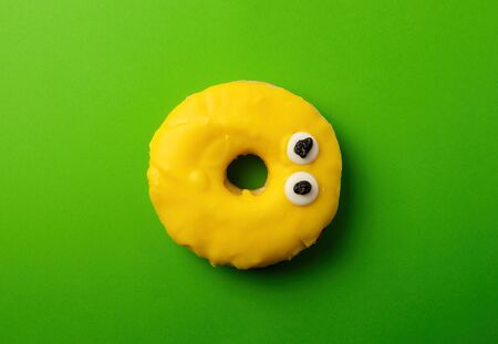 round yellow banana donut on a green background, flat layの写真素材