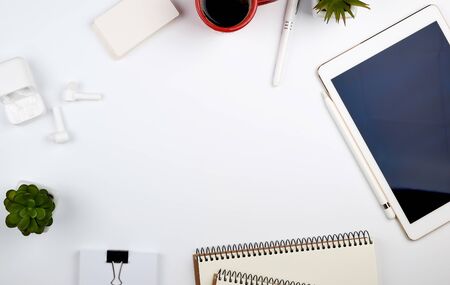 white table with electronic tablet, blank business cards, cup of coffee and wireless headphones, workplace of a freelancer or designer, top view, copy spaceの写真素材
