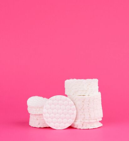 stack of white cotton round discs for cosmetic procedures on a pink backgroundの写真素材