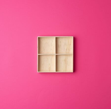square wooden box divided into storage cells for small things on a pink background, top viewの写真素材