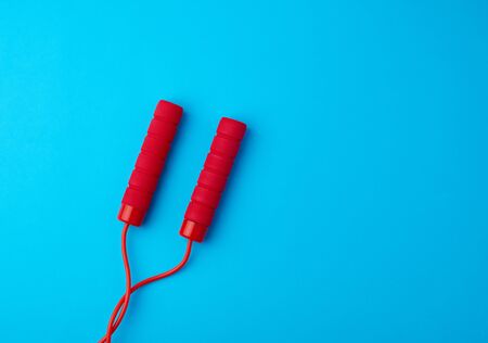 fragment of red rope for sports on a blue background, two neoprene handleの写真素材