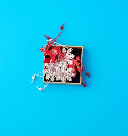 wooden carved Christmas decorations for the holiday tree, blue backgroundの写真素材