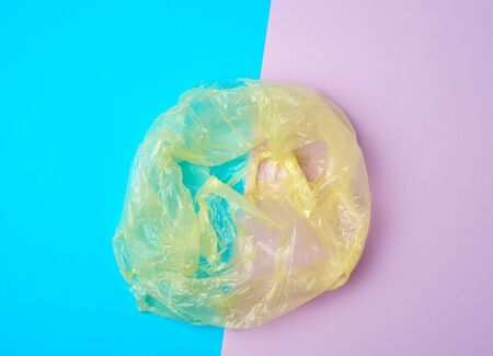 open empty plastic bag for products on a colored background, concept of rejection of plastic bags to...
