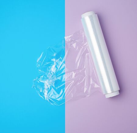 roll with transparent white polyethylene for wrapping products and packaging goods on a colored...