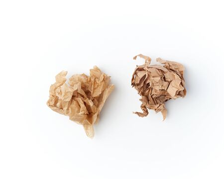 two crumpled sheets of brown paper on a white background, close up, top viewの写真素材