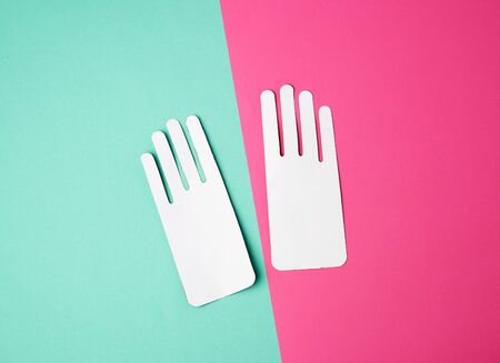 two empty paper white patterns for gloves on a colored backgroundの写真素材
