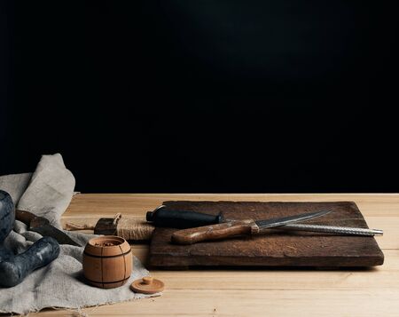 old sharp knife and sharpener with a handle on a wooden background, copy space