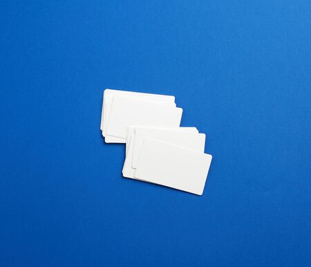 stack of rectangular white blank business cards on a blue background. Corporate business conceptの写真素材