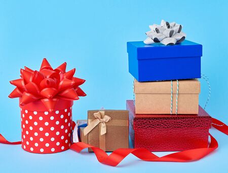 stack of wrapped gifts with knotted bows on a blue background, festive backdrop